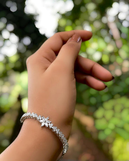 Daisy Thread | A rhodium-finished tennis-style bracelet featuring delicate American Diamond stones & a central bloom.