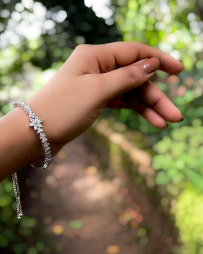 Daisy Thread | A rhodium-finished tennis-style bracelet featuring delicate American Diamond stones & a central bloom.