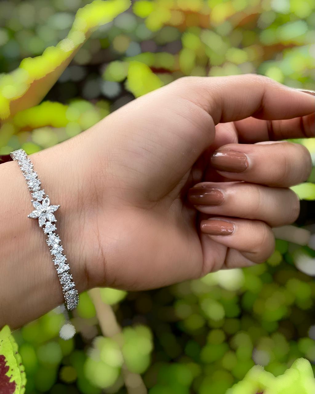Daisy Thread | A rhodium-finished tennis-style bracelet featuring delicate American Diamond stones & a central bloom.